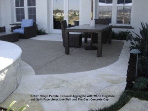  3_16” ‘Noiyo Pebble’ Exposed Aggregate with White Flagstone and Split Face Limestone Wall and Pre-Cast Concrete Cap