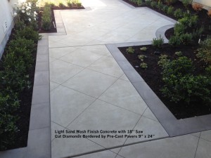 Light Sand Wash Finish Concrete with 18” Saw Cut Diamonds.  Bordered by Pre-Cast Pavers 9” x 24” 
