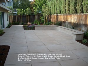 Light Sand Wash Finish Concrete with Unknown Integral  Color 42” Squares. 18“ Seatwall with Stucco Walls to Match House & a Pre-Cast Bull Nosed Concrete Cap to Match Patio Color - 14” Wide. 