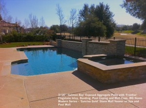 16” ‘Salmon Bay’ Exposed Aggregate Patio with ‘Frontier’ Flagstone Inlay, Banding, Pool Coping and Wall Caps. MG Home Modern Series - ‘Sunrise Gold’ Stone Wall Veneer on Spa and Pool Wall