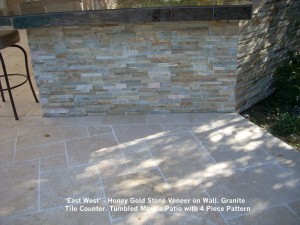 ‘East West’ - Honey Gold Stone Veneer on Wall. Granite Tile Counter. Tumbled Marble Patio with 4 Piece Pattern