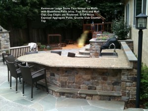 Kennesaw Ledge Stone Thin Veneer on Walls  with Bluestone Patio Inlay, Foot Rest and Wall Cap. Cap Edges are Routered. 3_16 Noiyo  Exposed Aggregate Patio. Granite Slab Counter Top